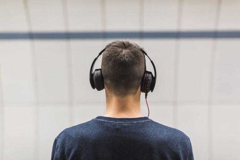Pria mengenakan headphone mendengarkan musik dengan santai